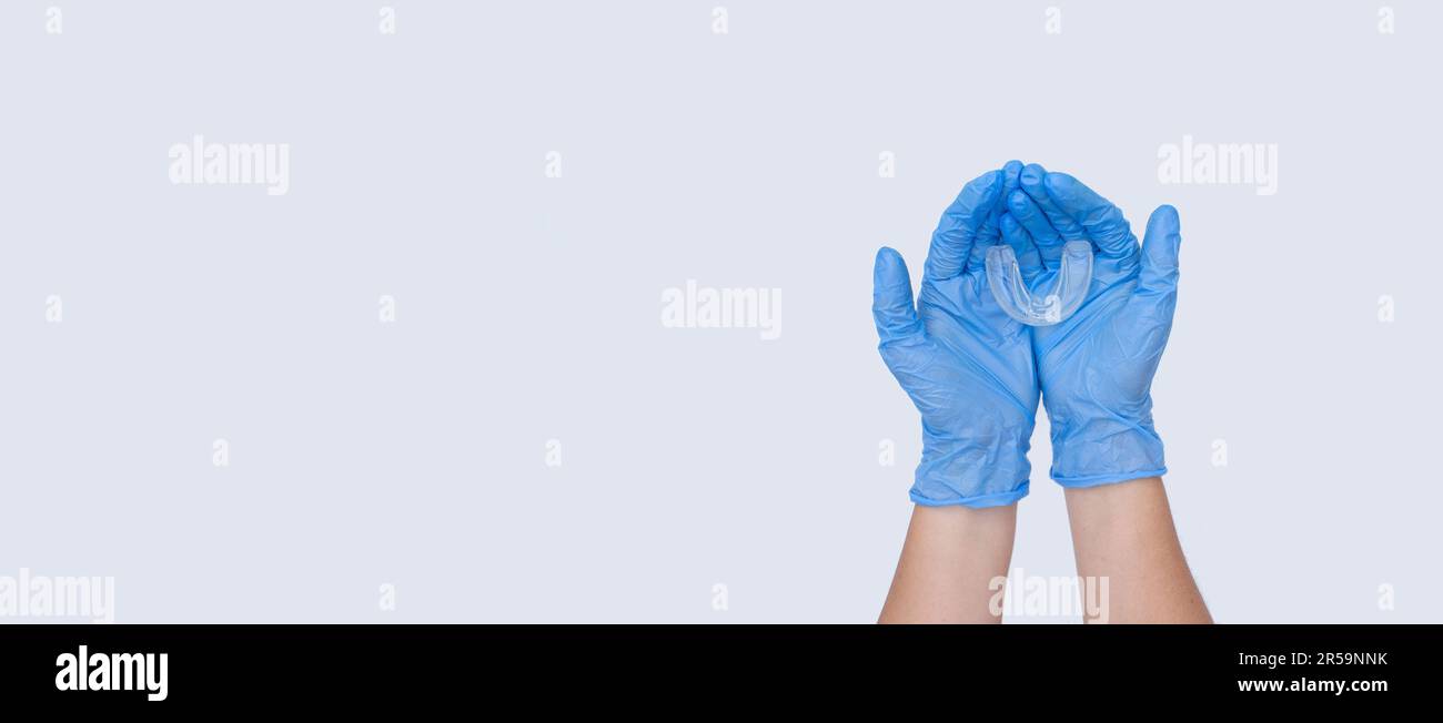 Doctors female hands holds silicone mouth guard. Concept of oral