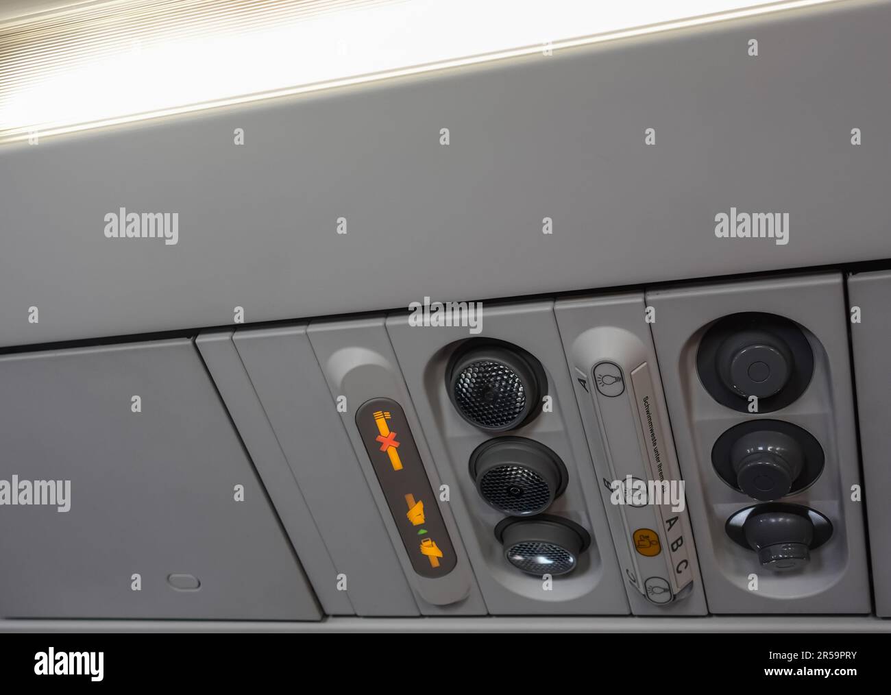ventilation signs and controls on the ceiling in an airplane during
