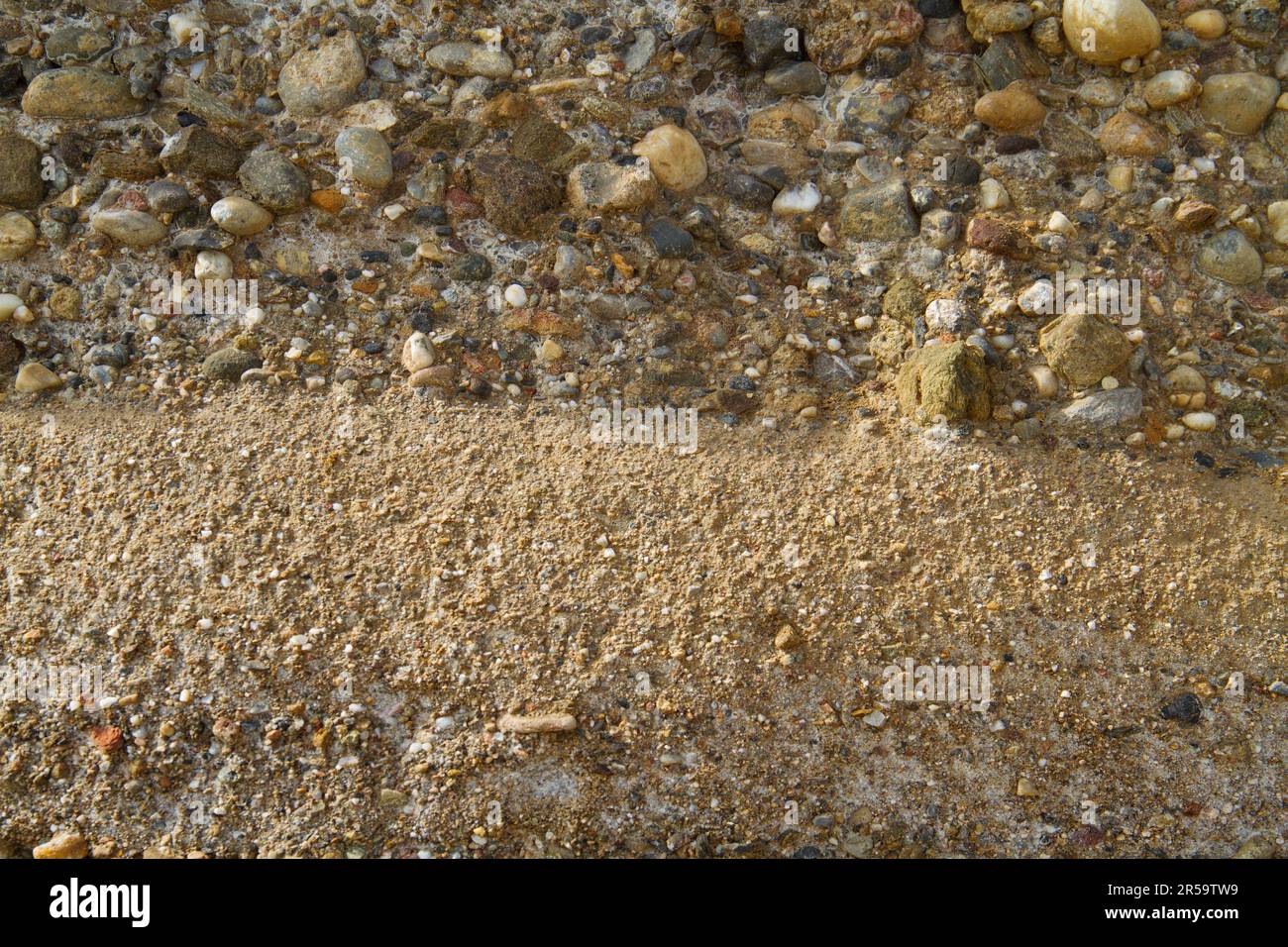 Layered sediment, consisting of a layer of rounded gravel and below that a layer of coarse sand Stock Photo