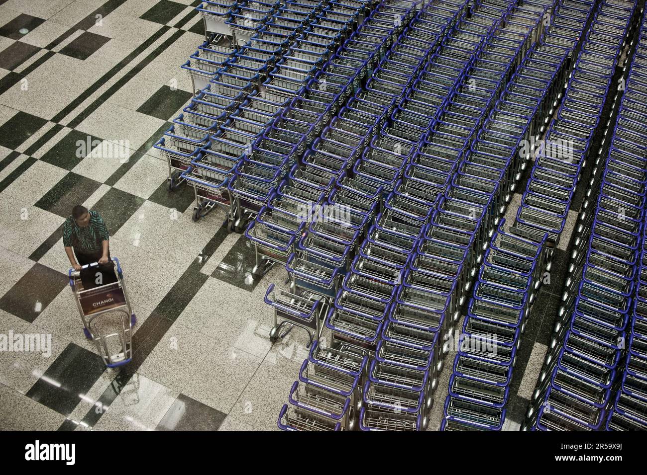 A traveler getting an airport trolley at Changi airport, Singapore. Stock Photo