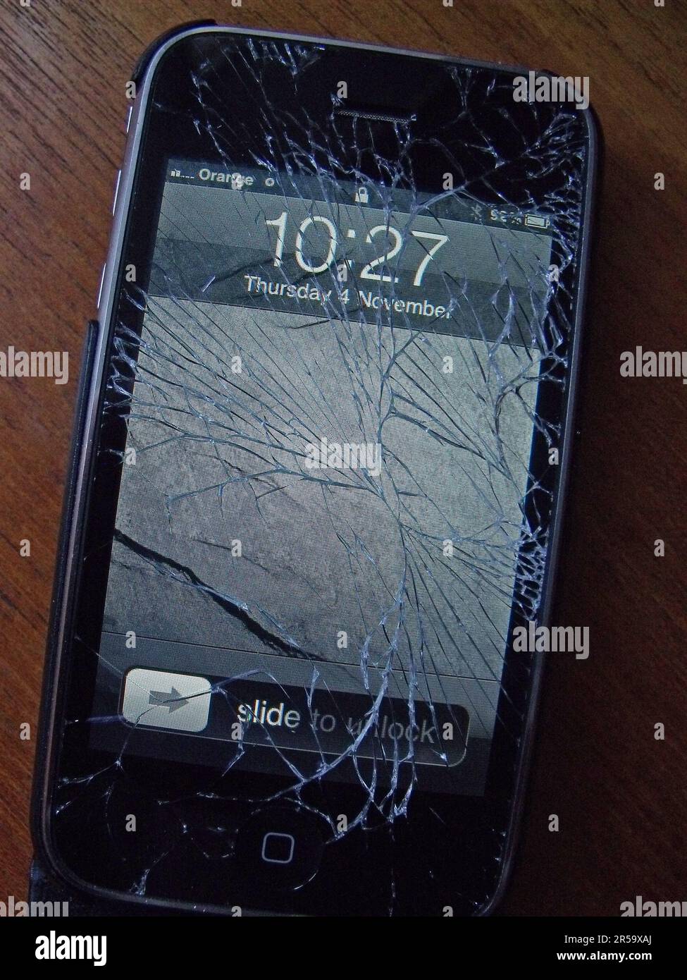 Smashed and cracked screen on an Apple Iphone, still functioning Stock Photo