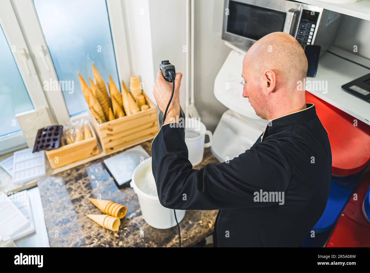 Ice cream making process Professional blender in bucket for churning