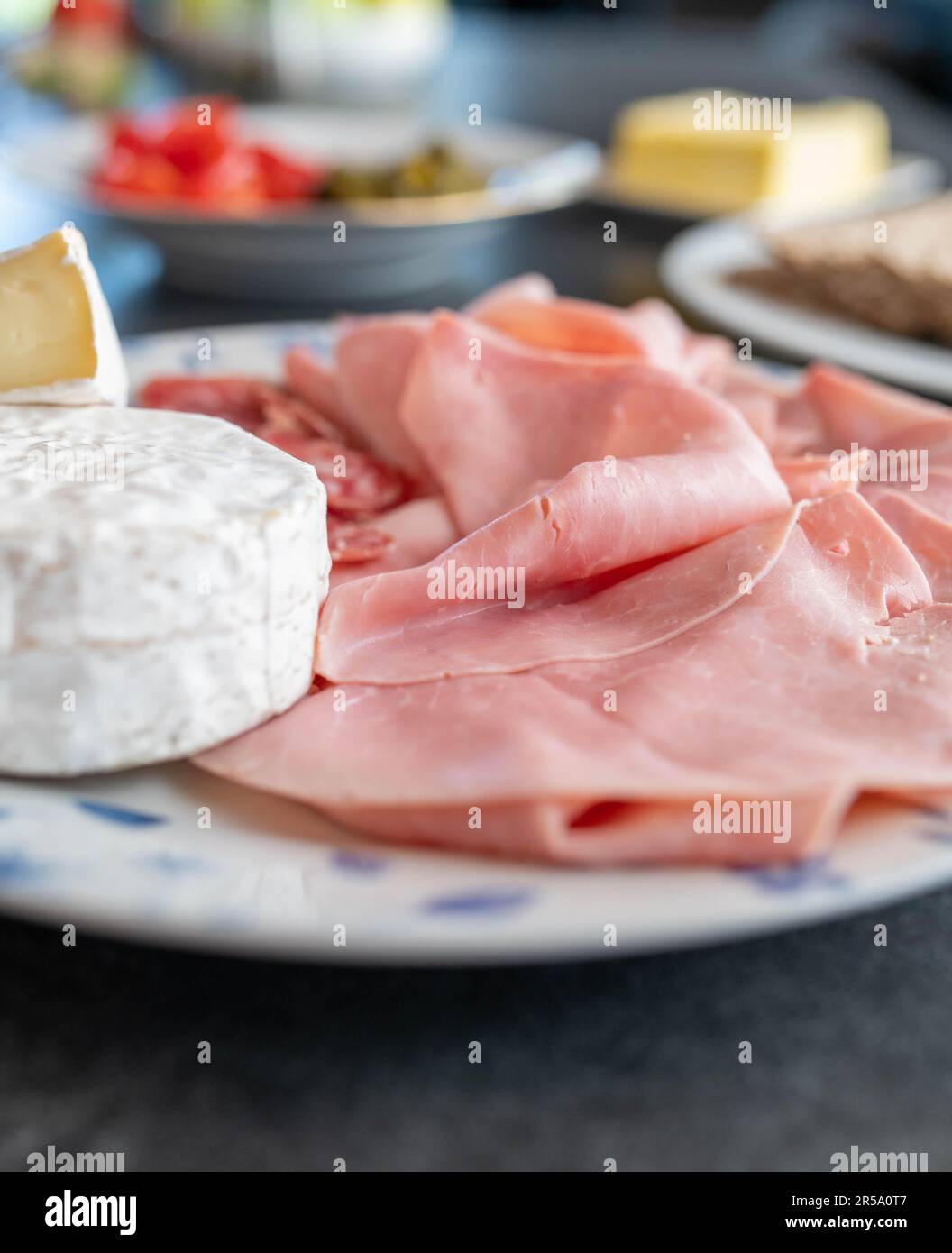 Plate with cold cuts and cheese on a dinner table Stock Photo