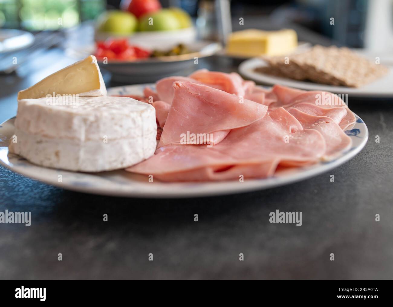 Plate with cold cuts and cheese on a dinner table Stock Photo