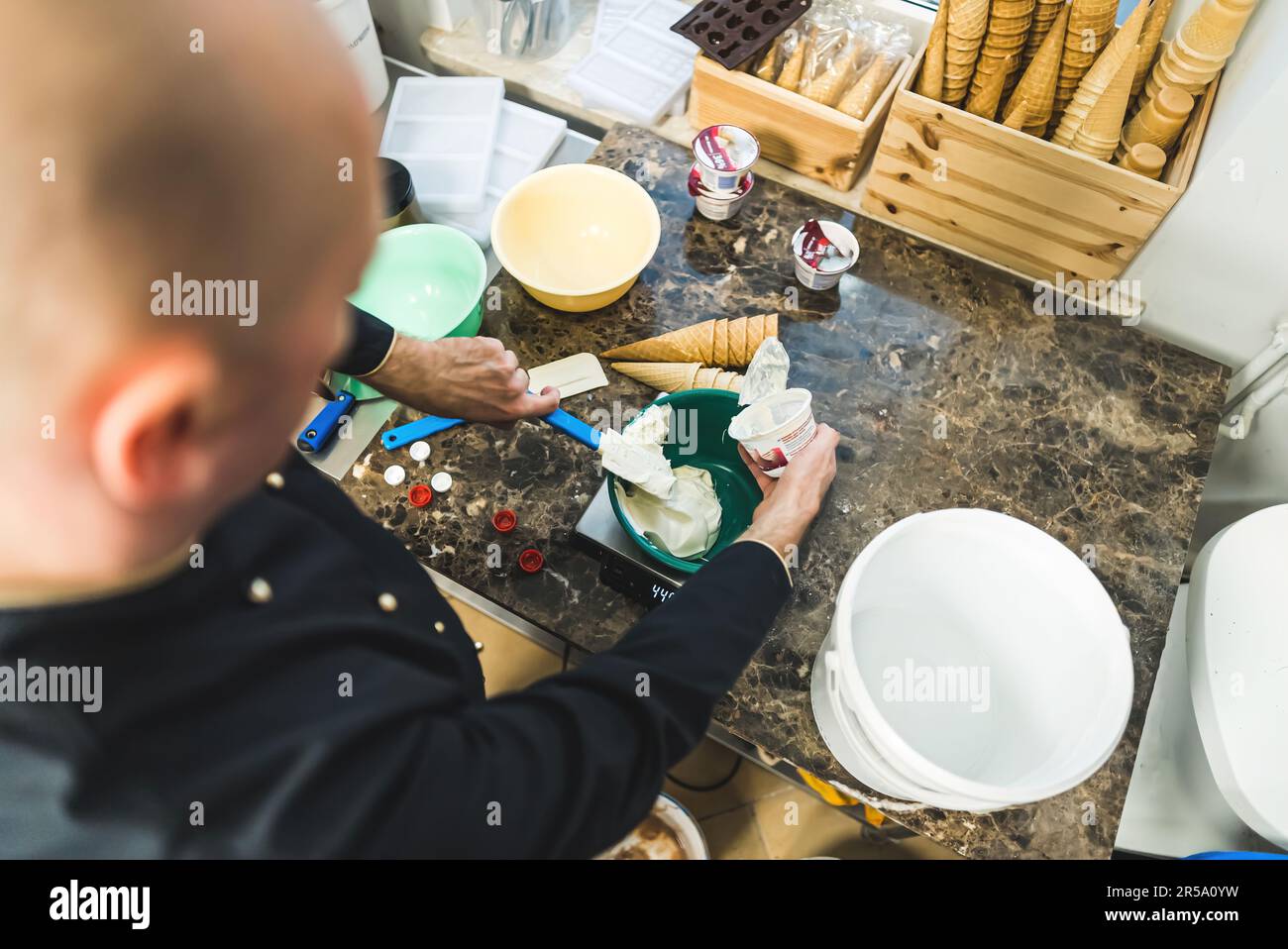 Hands of chef pour cream into bucket to make ice cream using blender in a bucket. High quality photo Stock Photo