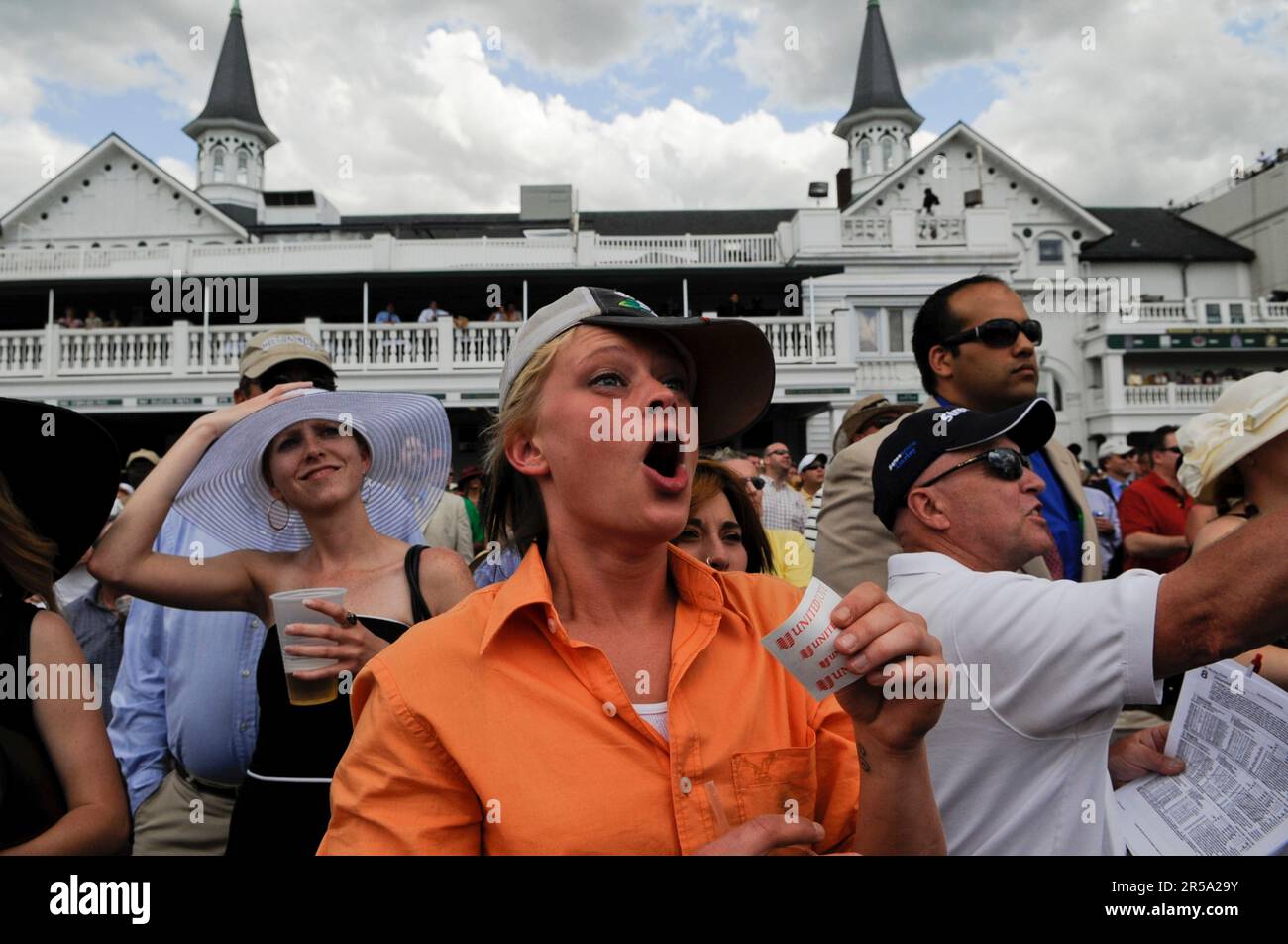 A horse racing spectator clutches her wager stub as she cheers her horse. Stock Photo