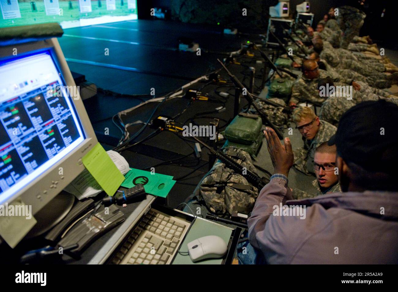 The indoor range instructor talks to soldiers about proper weapon holding during their preliminary weapons training course. Stock Photo