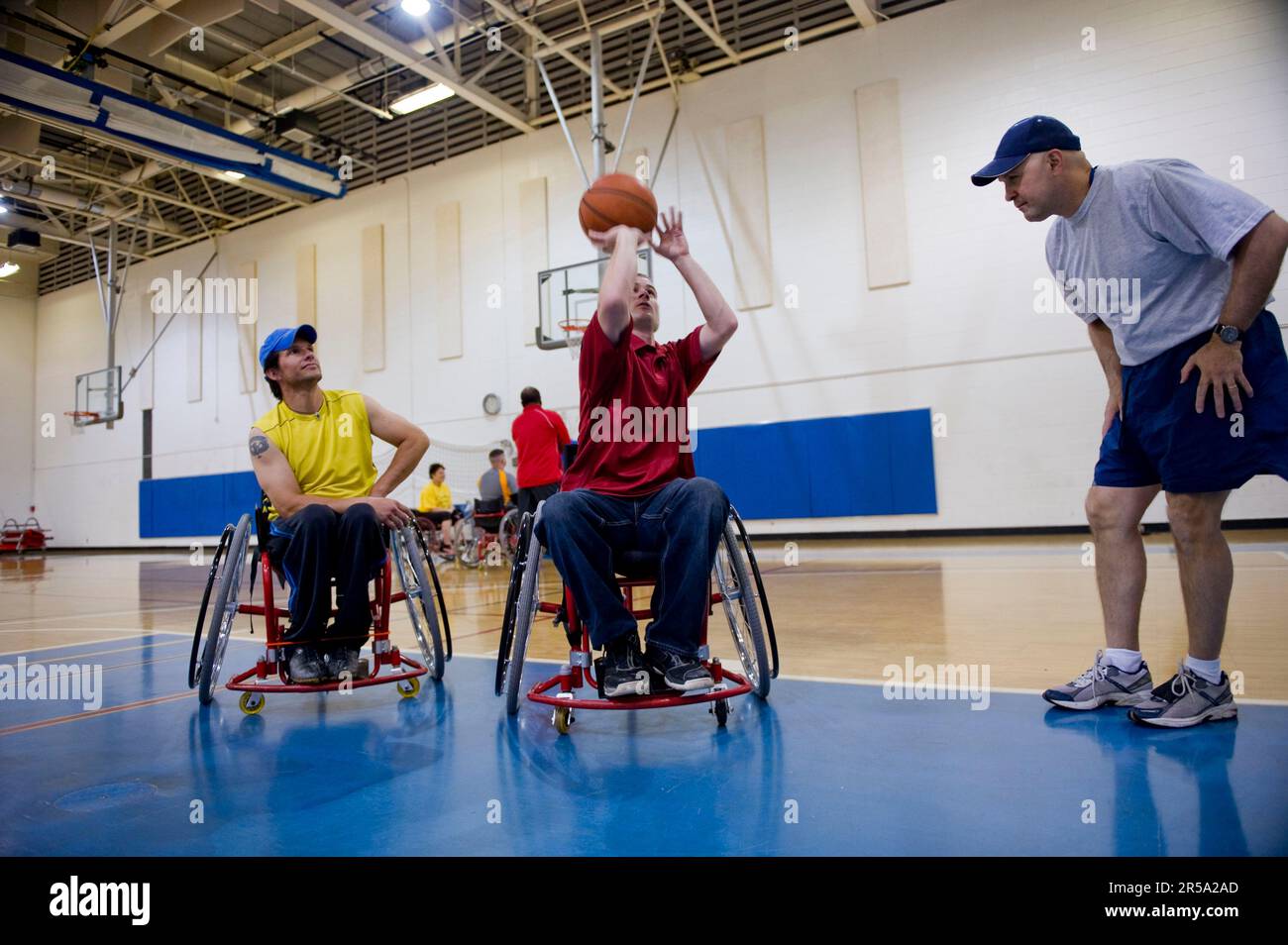 A coach demonstrates ball handling from a wheelchair during wheelchair