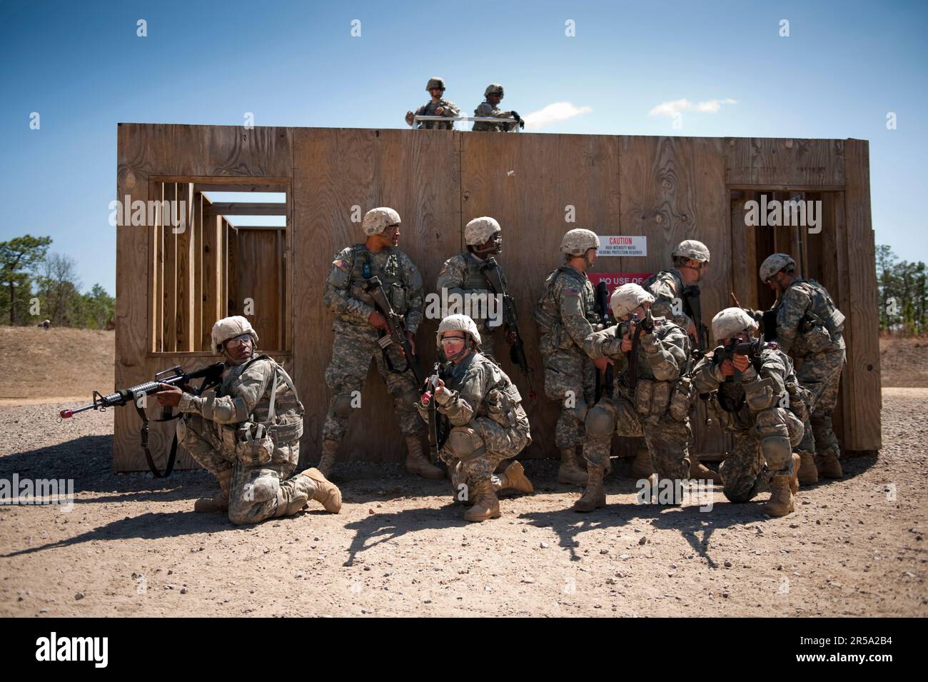 Soldiers in basic training move tactically as a squad during close quarters combat training. Stock Photo