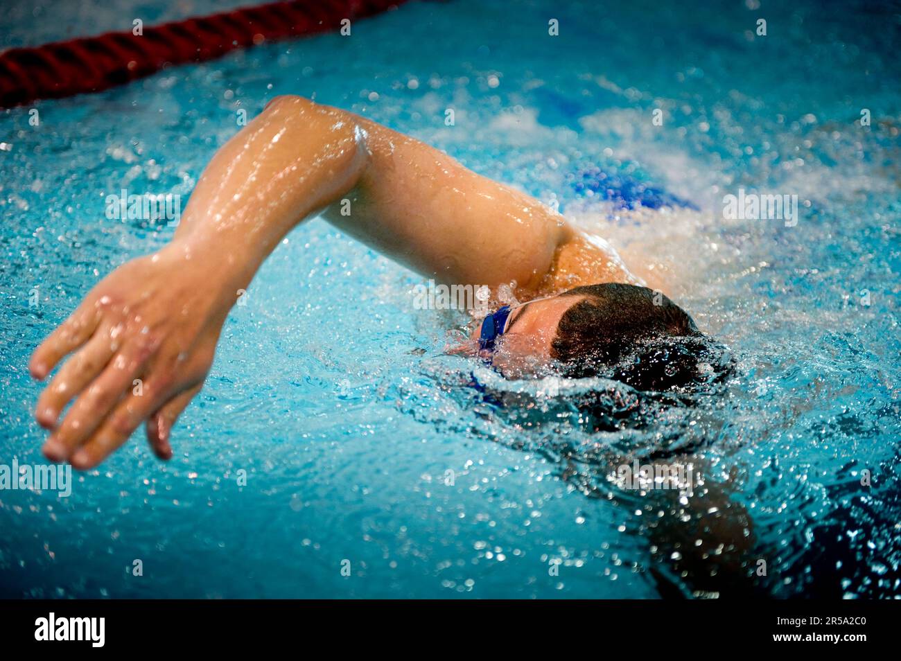 An athlete, who only has one leg, swims laps during practice Stock