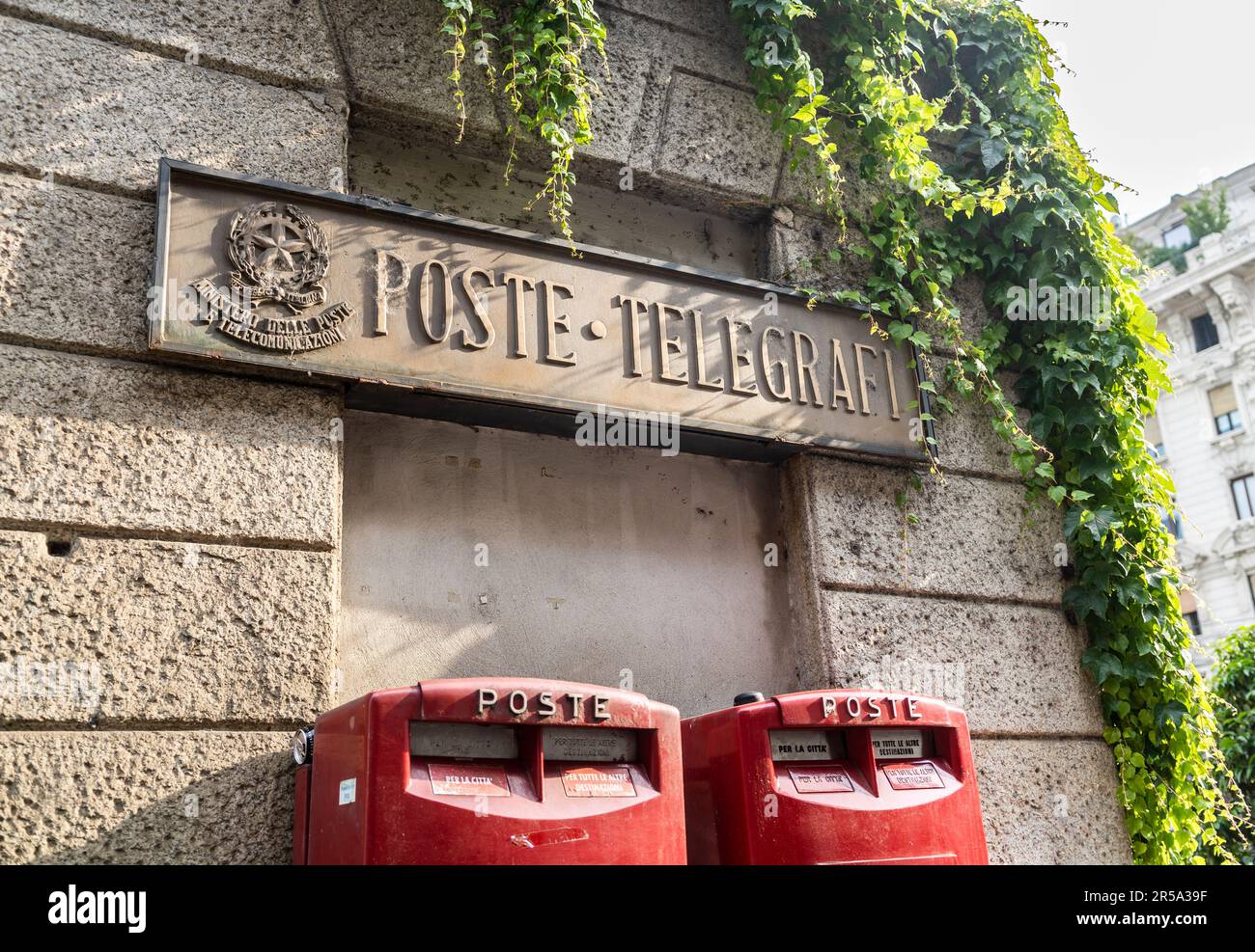 Old stone signboard meaning "Poste e Telegrafi" and two modern red mail