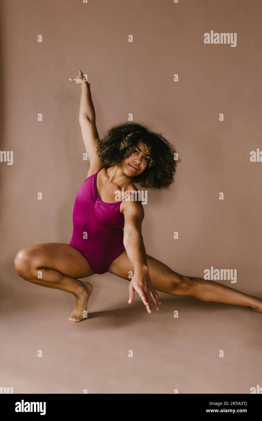 Contemporary dancer posed in studio in pink leotard in studio Stock Photo
