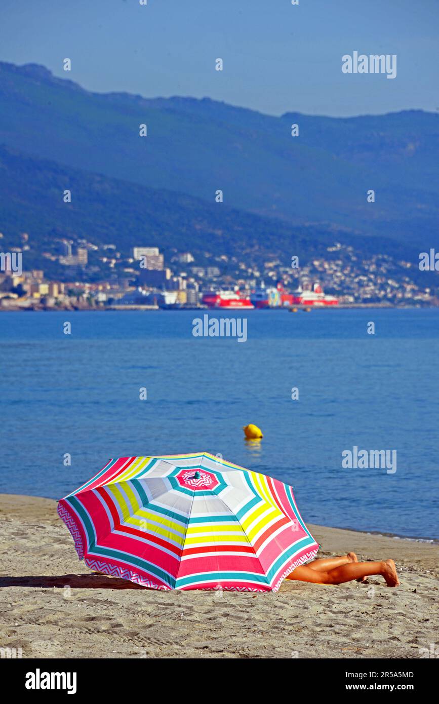 colorful parasol on the beach, Bastia in the background, France, Corsica, Biguglia Stock Photo