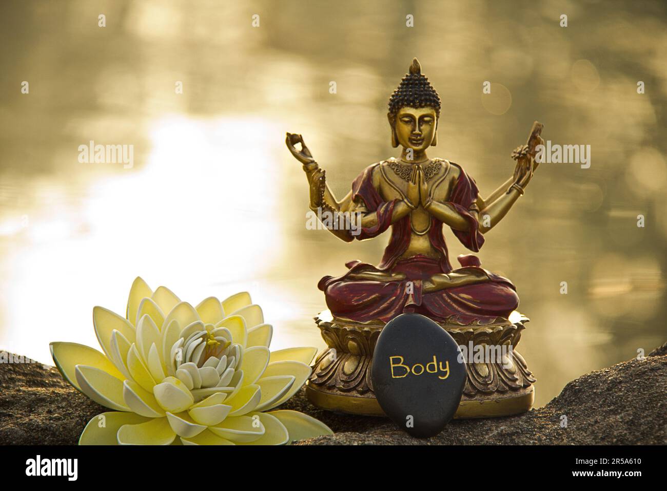six-armed buddha by the water with Lotos flower in the morning Stock Photo