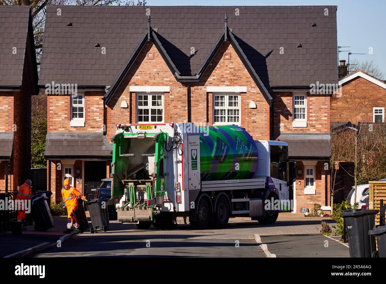 Bin men loading household rubbish into a lorry destined to landfills tips at  Lower Peover, Cheshire Stock Photo