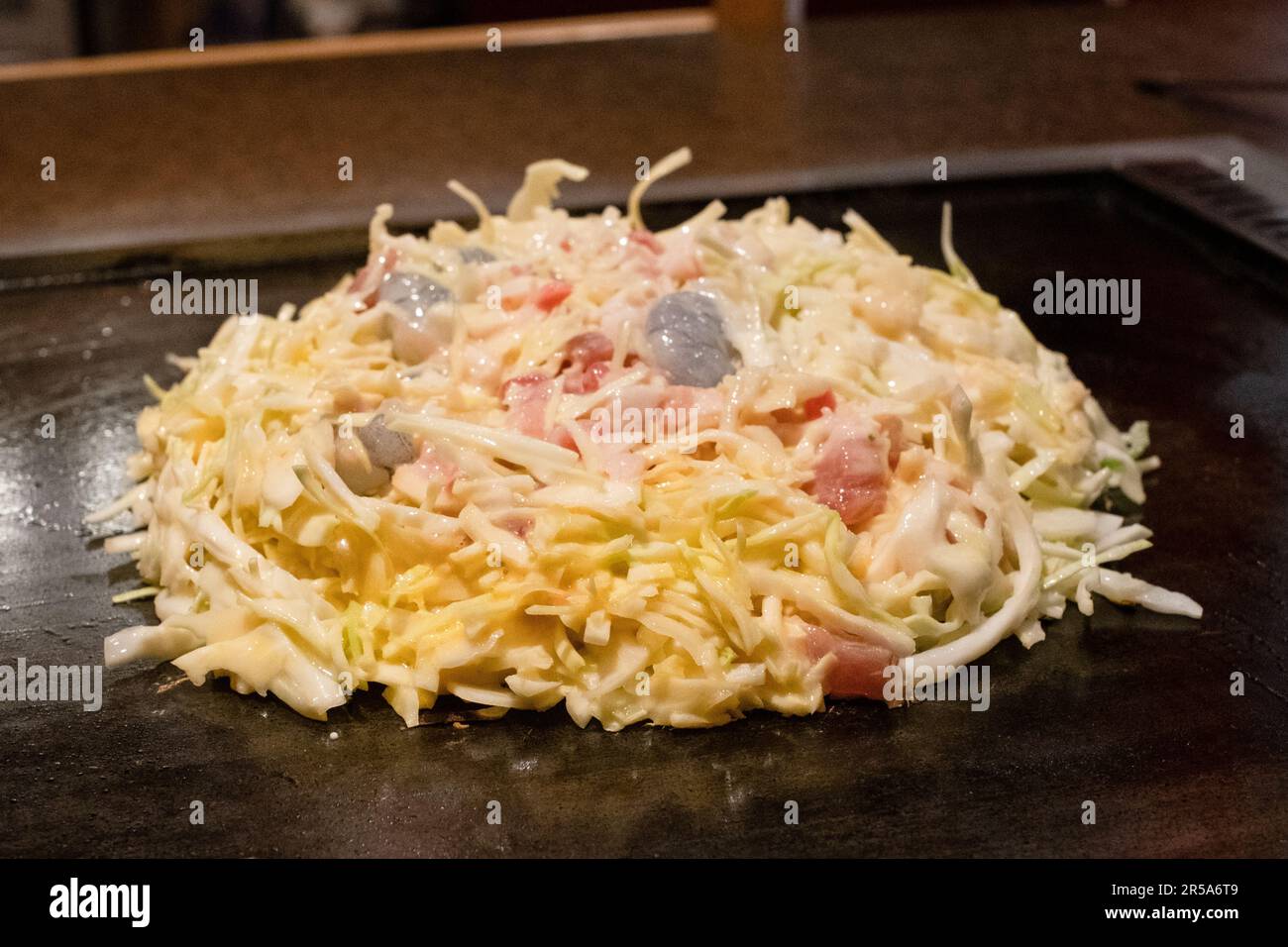 Okonomiyaki cooking on a hotplate at the table, Tokyo, Japan. Stock Photo
