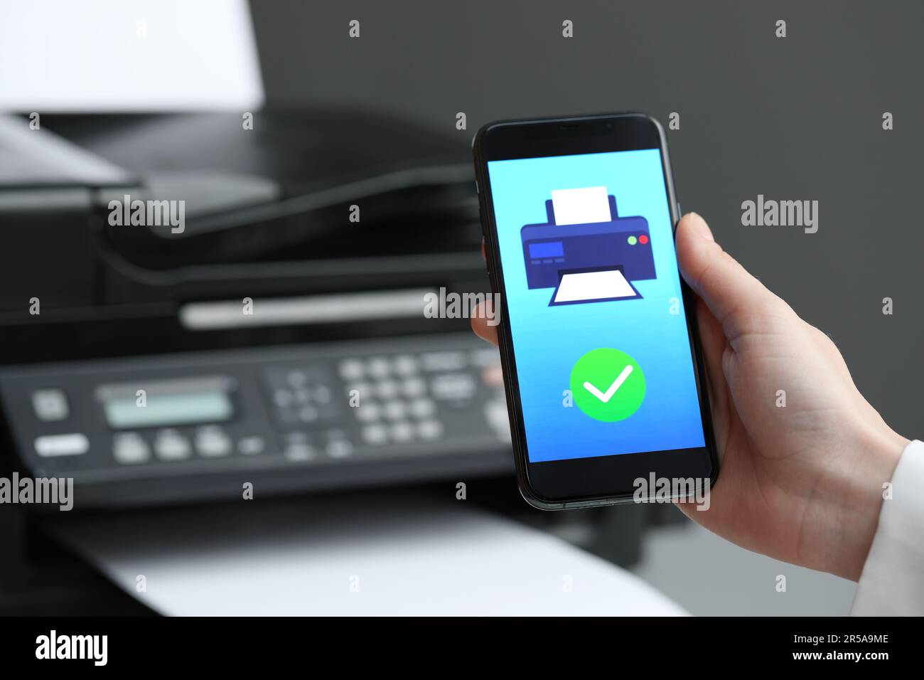 Man using printer management application on mobile phone indoors, closeup and space for text Stock Photo