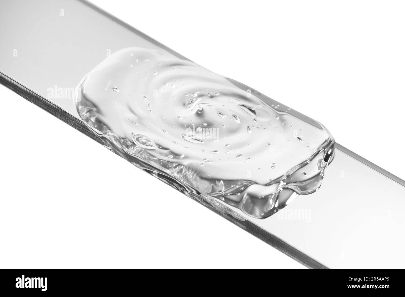 Glass slide with clear face gel on white background, closeup Stock
