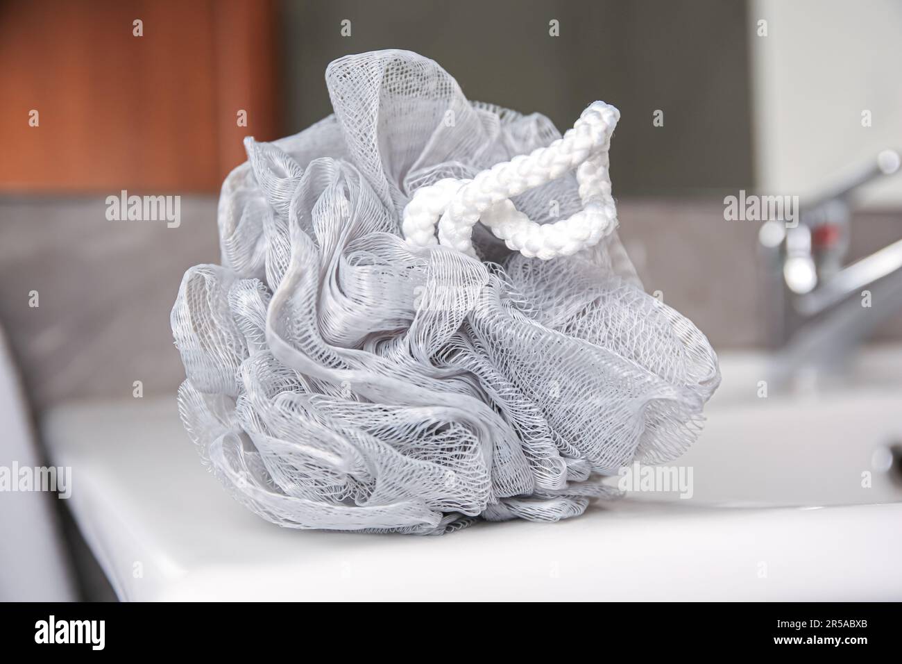 Grey shower puff on washbasin in bathroom, closeup Stock Photo - Alamy