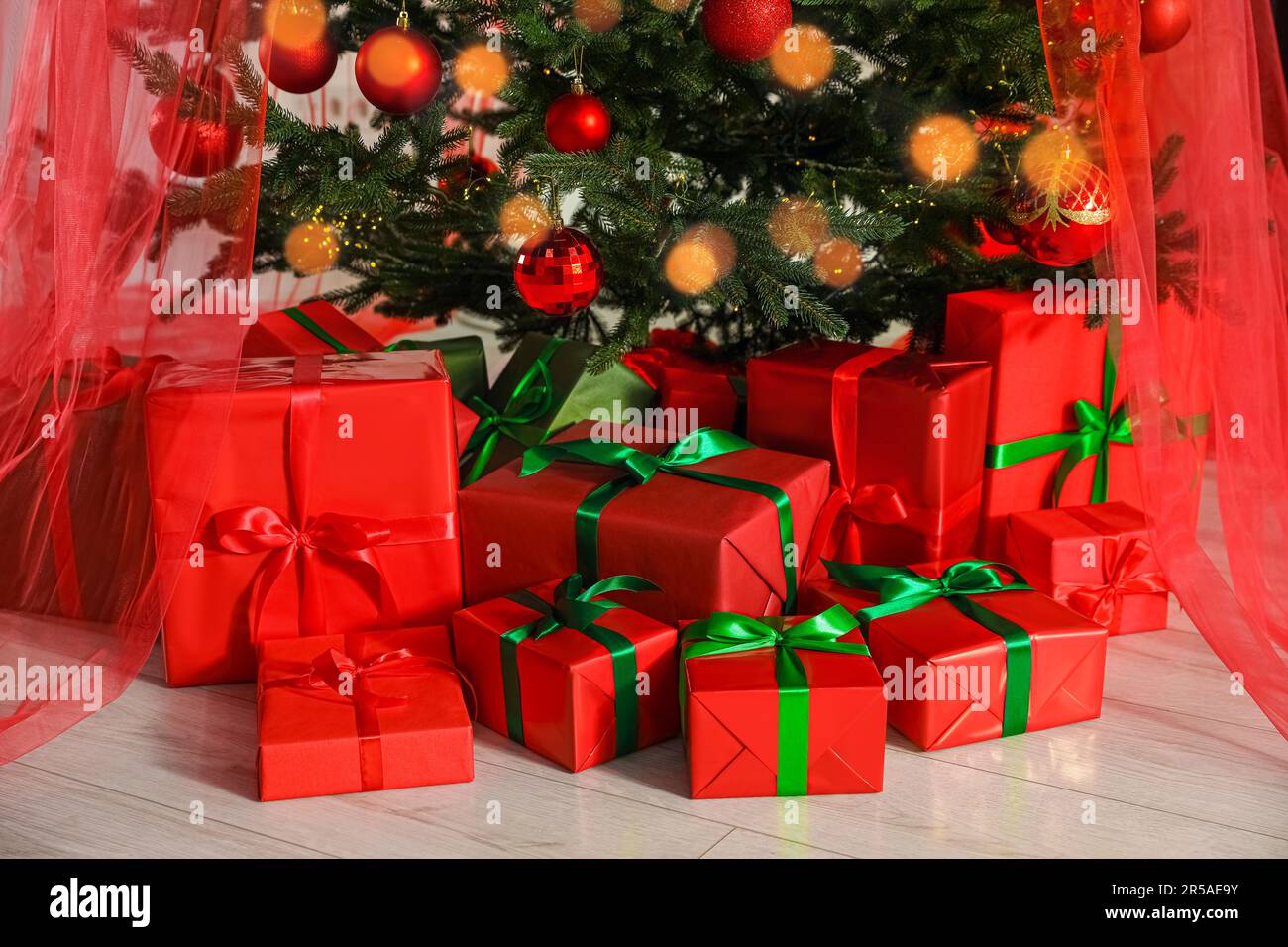 Beautifully wrapped gift boxes under Christmas tree indoors Stock Photo