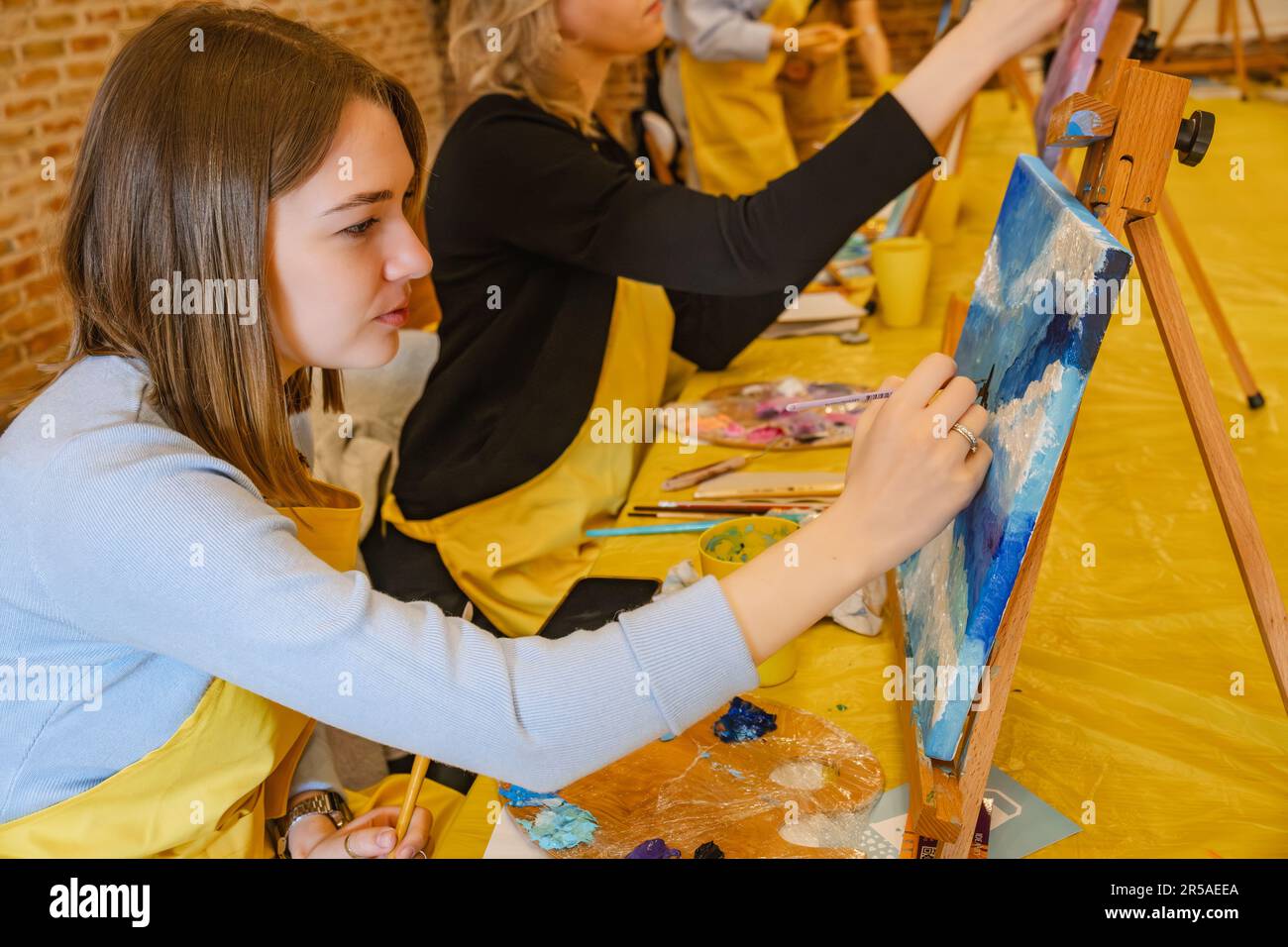 Woman paint brush canvas friends hi-res stock photography and images ...