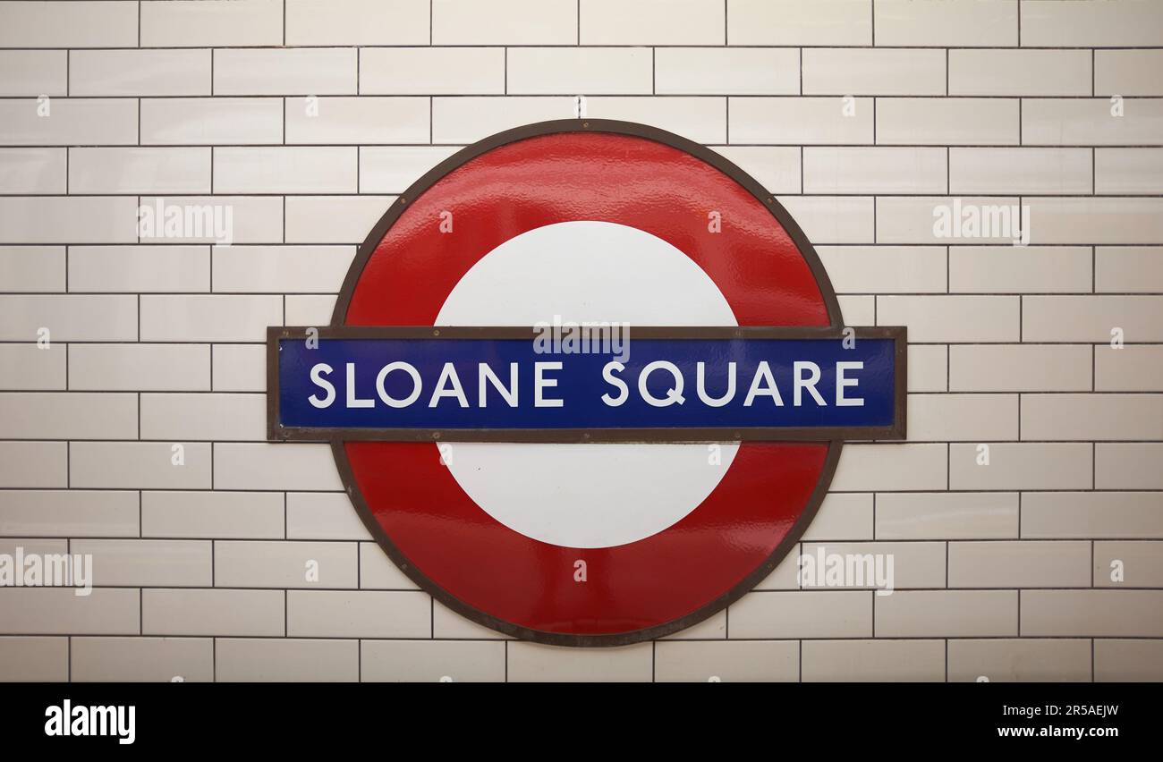 LONDON, UK - 27 APRIL 2022: Close up of the Sloane Square tube station sign against white tiles on the station wall.  Circle and District Lines. Stock Photo