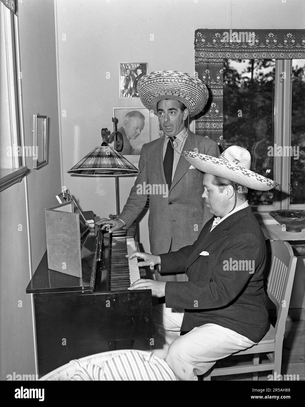In the 1940s. Two men in mexican hats at a piano, one playing and one singing. They are operasinger Jussi Björling 1911-1969 playing, and the american moviestar Eddie Cantor. Sweden 1946  ref 218a-1 Stock Photo