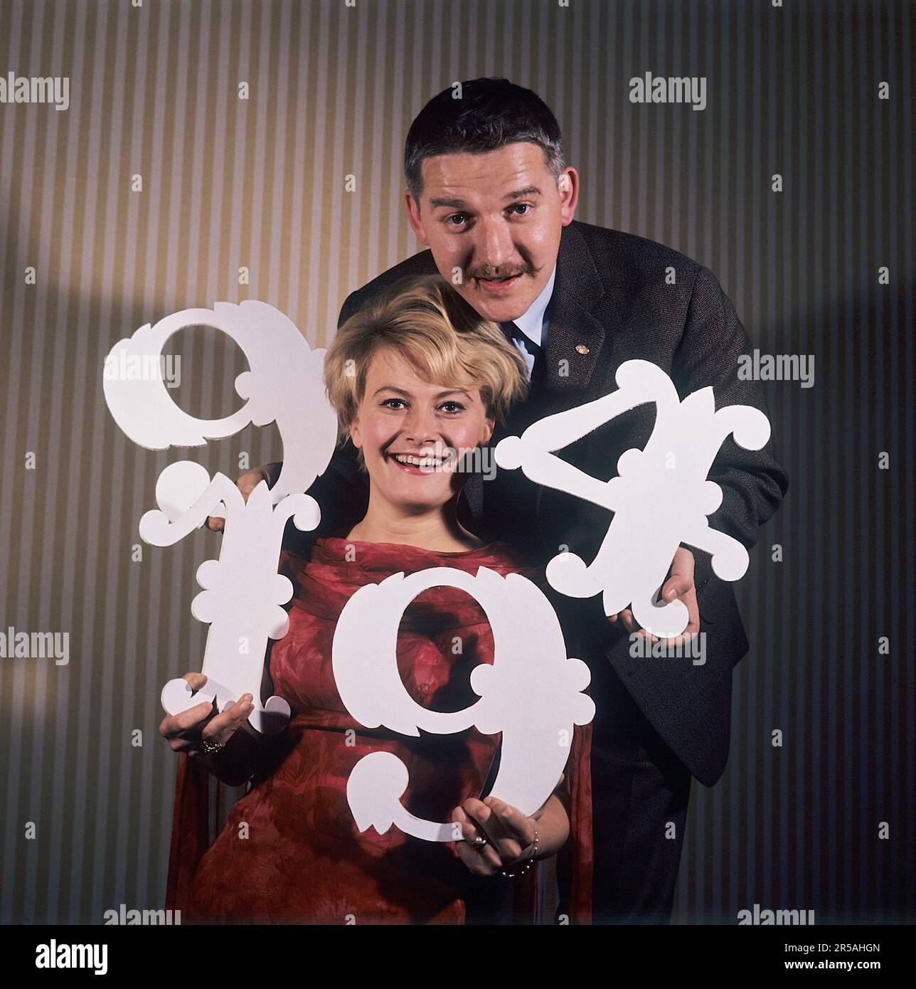 Fun with numbers in the 1960s. A woman and a man are holding different ...