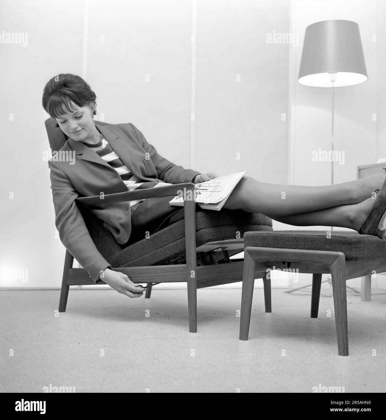 Home decor of the 1960s. A woman is sitting comfortably in a chair ...