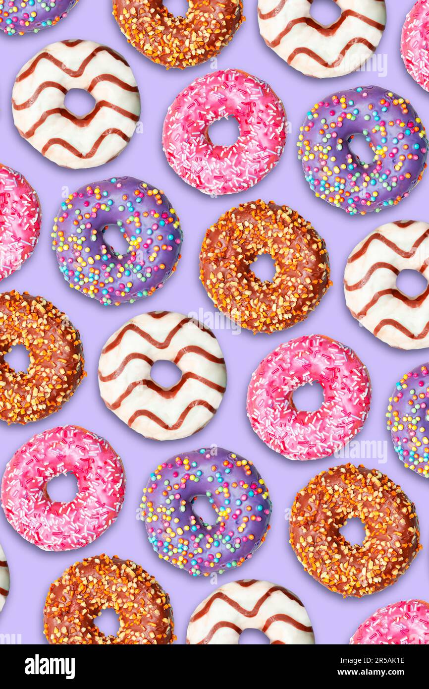 Repeating pattern of colorful donuts on a lilac background. Stock Photo