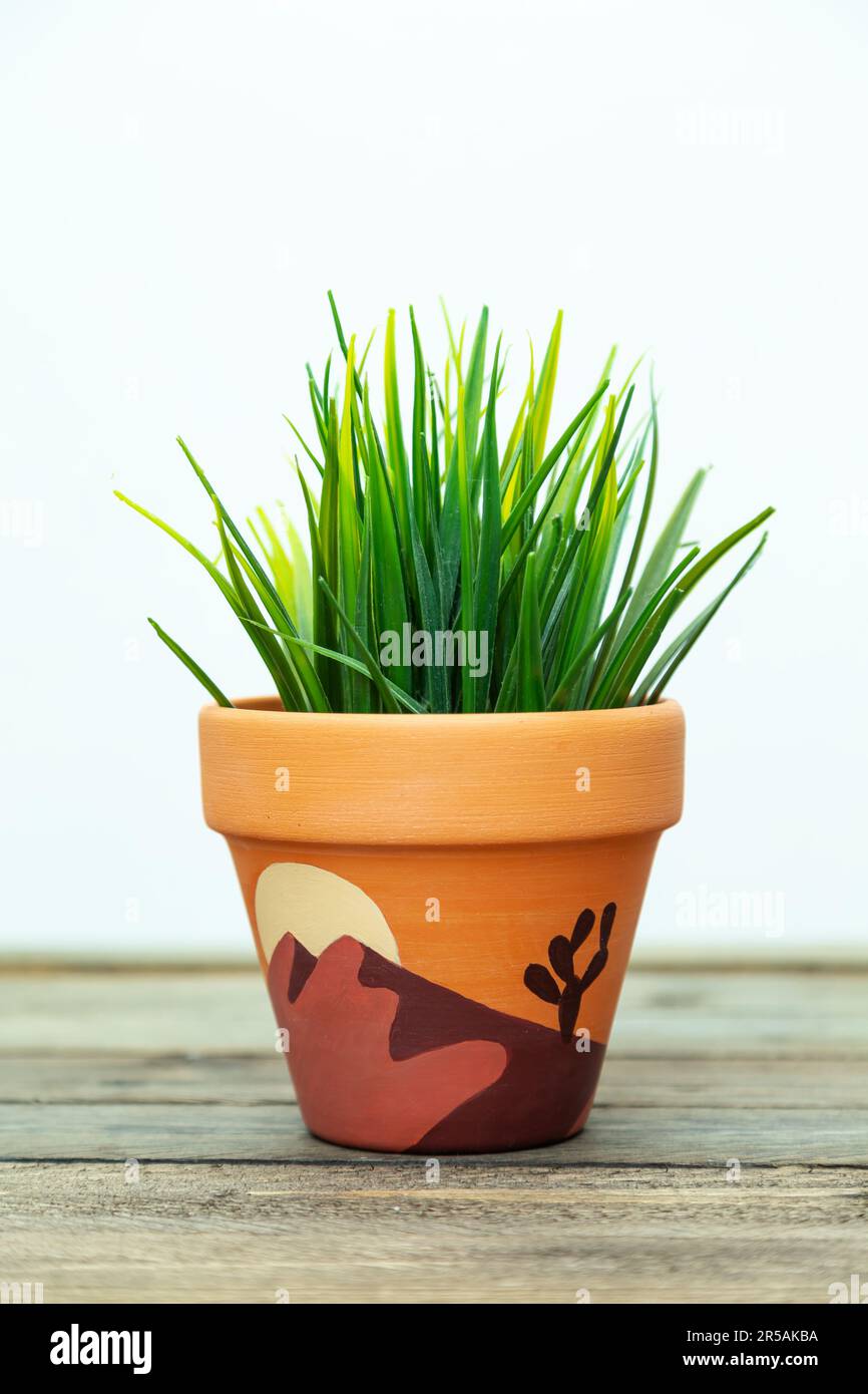 Artificial plant in a clay terracotta pot. Hand painted with acrylics