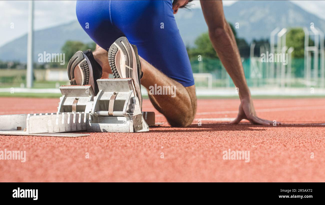 Caucasian male arms and hands on the running track starting line, ready, set and go sprint position Stock Photo