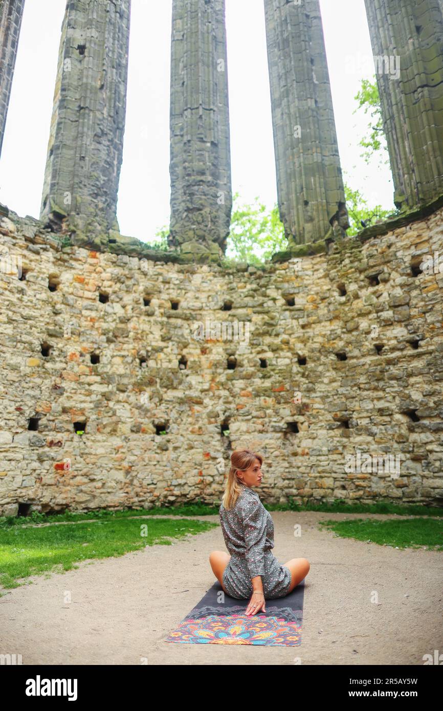 girl meditating in the ruins of an old church Stock Photo