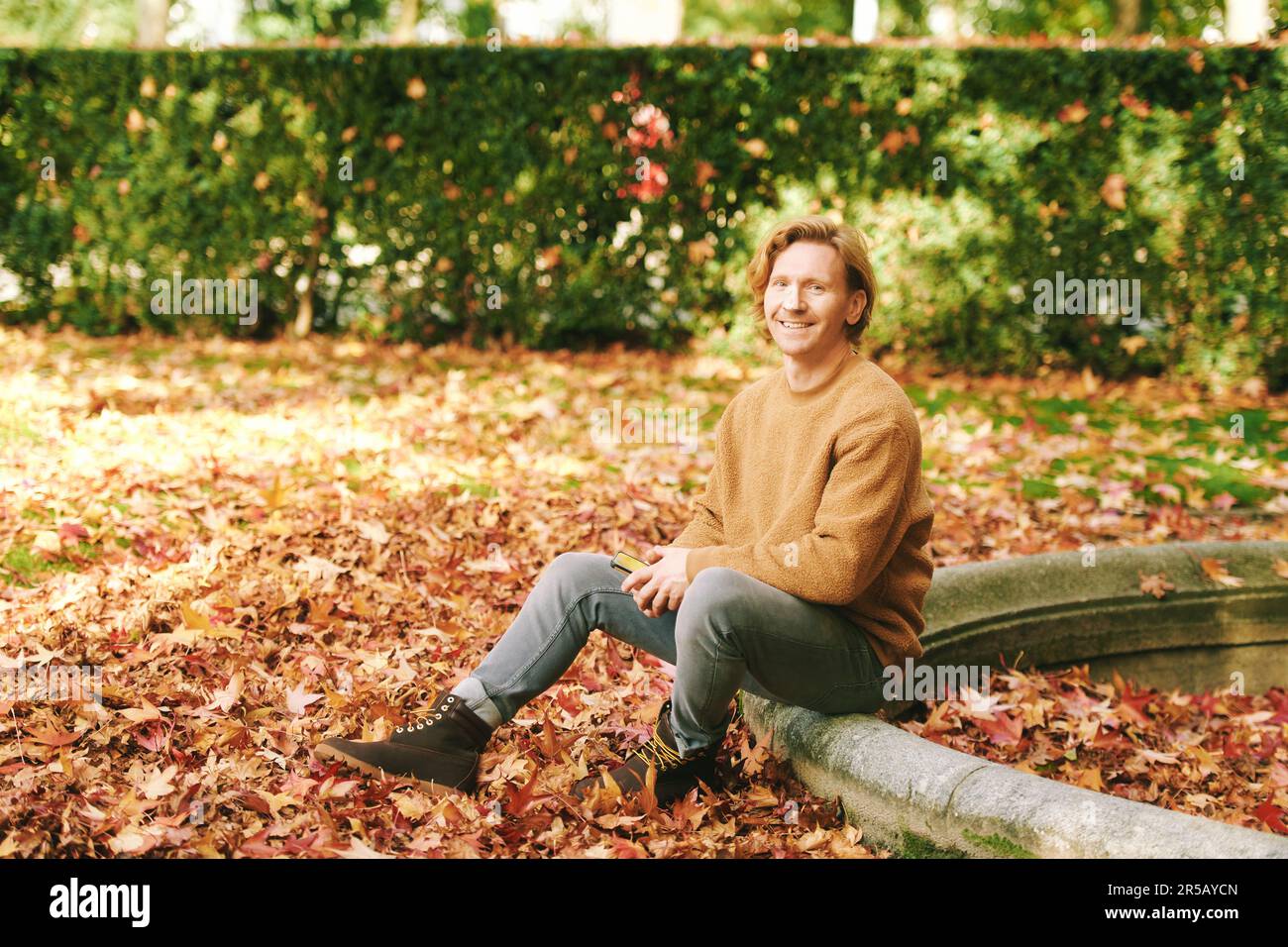 Outdoor portrait of handsome mature man in autumn park Stock Photo