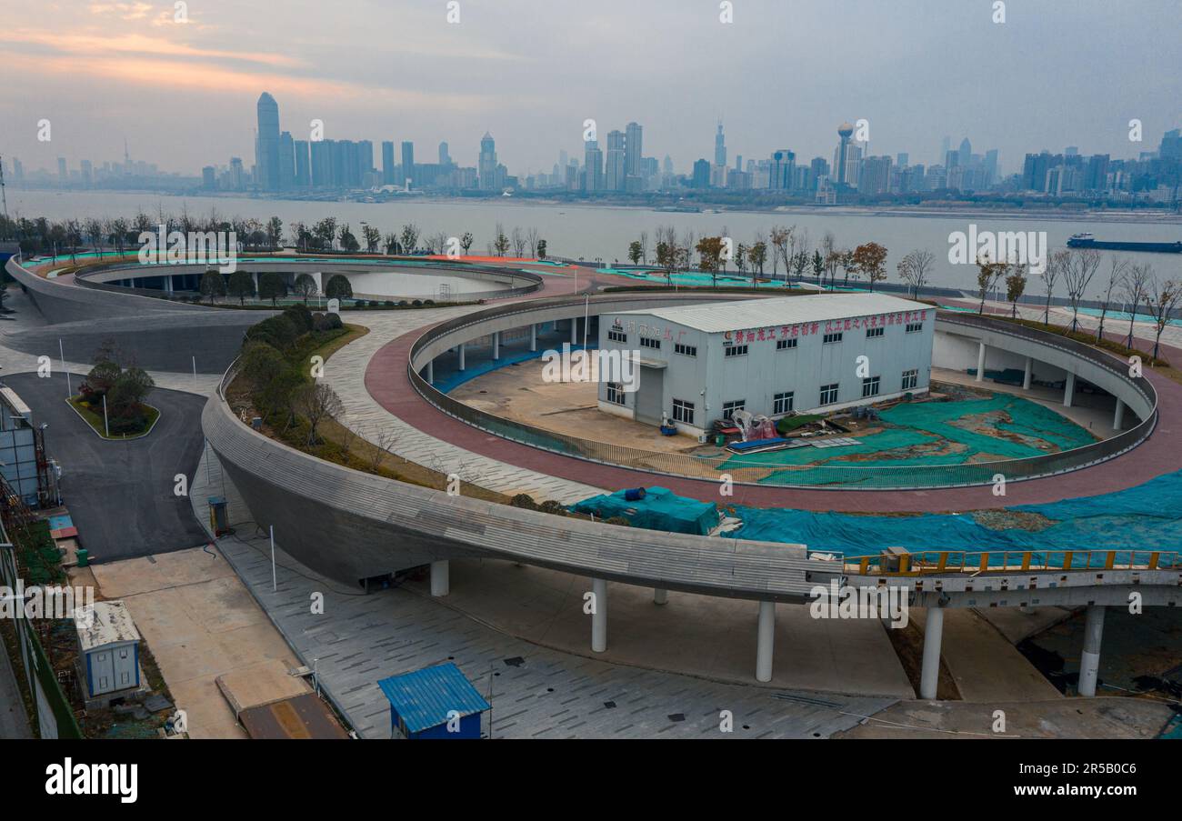 A circular parking lot and pedestrian walkway with a view of an urban cityscape below Stock Photo