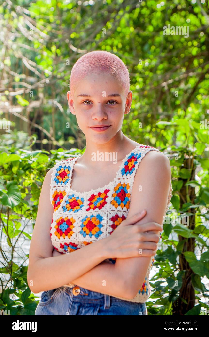Portrait of a girl with very short hair, painted pink.Portrait of girl wearing crochet clothes. Stock Photo