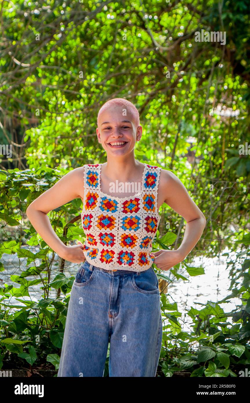 Portrait of a girl with very short hair, painted pink.Portrait of girl wearing crochet clothes. Stock Photo