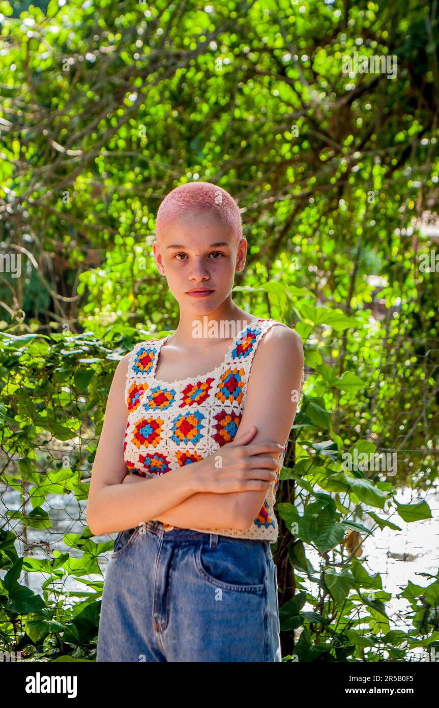 Portrait of a girl with very short hair, painted pink.Portrait of girl wearing crochet clothes. Stock Photo