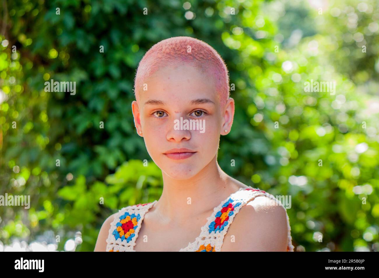 Portrait of a girl with very short hair, painted pink.Portrait of girl