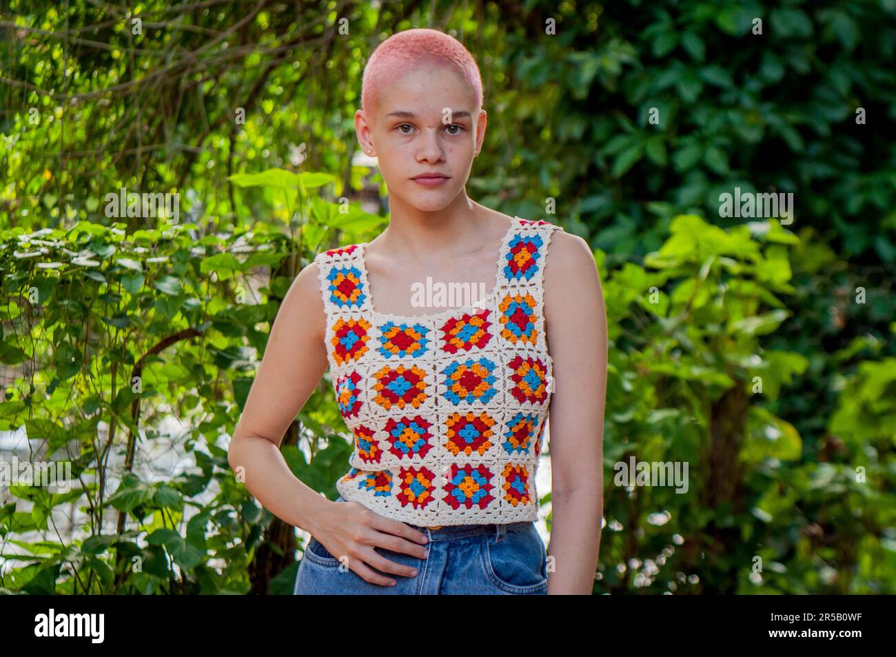 Portrait of a girl with very short hair, painted pink.Portrait of girl