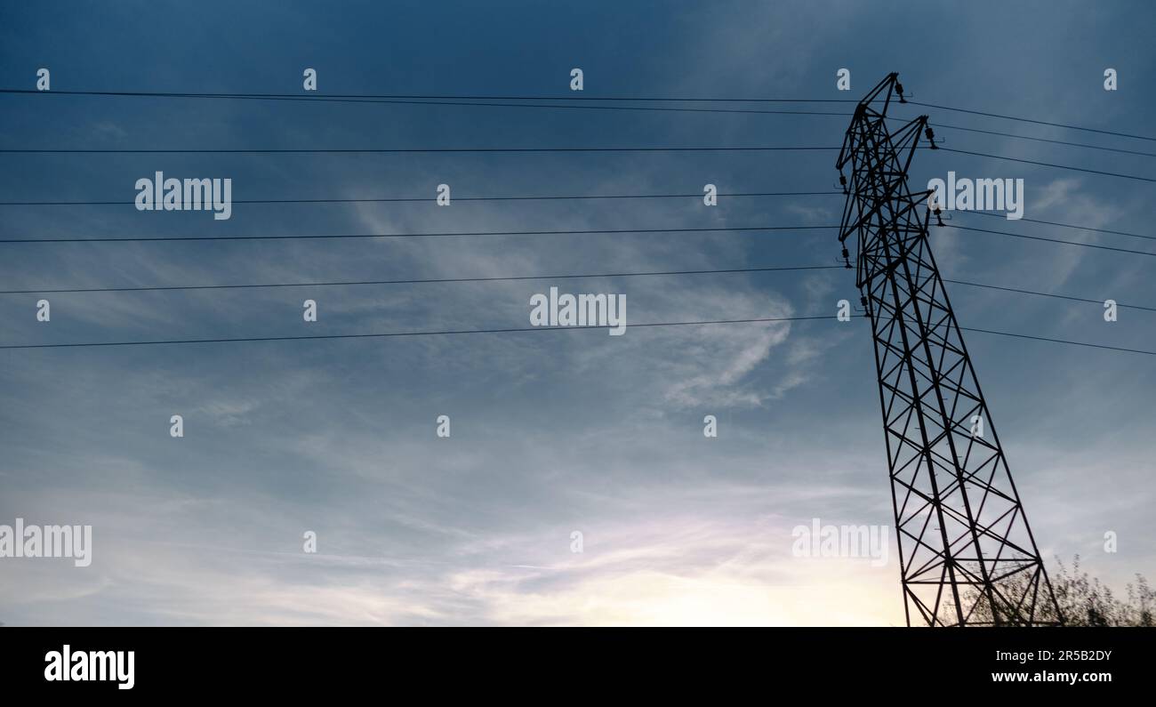 Electricity post high voltage power lines at low angle view ...
