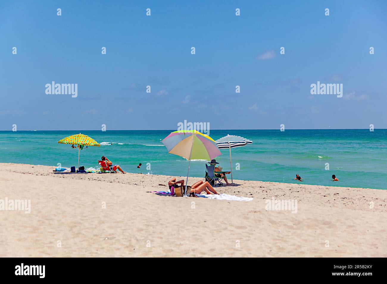 Miami USA July 27 2010 people enjoy sitting in beach chaires with parasol at the fine sand of south beach Miami Stock Photo Alamy