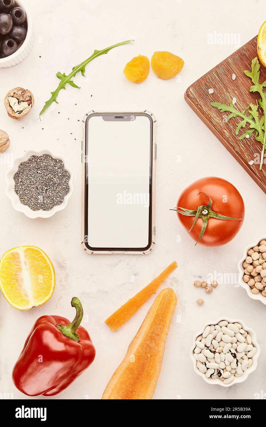 Fodmap, Mediterranean, Paleo diet concept. Screen mobile phone mockup. Healthy low fodmap food - vegetables, chickpeas, fruits, beans, nuts, greens. Stock Photo
