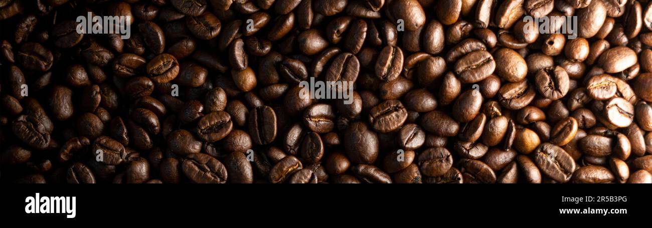 A pile of brown coffee beans - wallpaper Stock Photo - Alamy