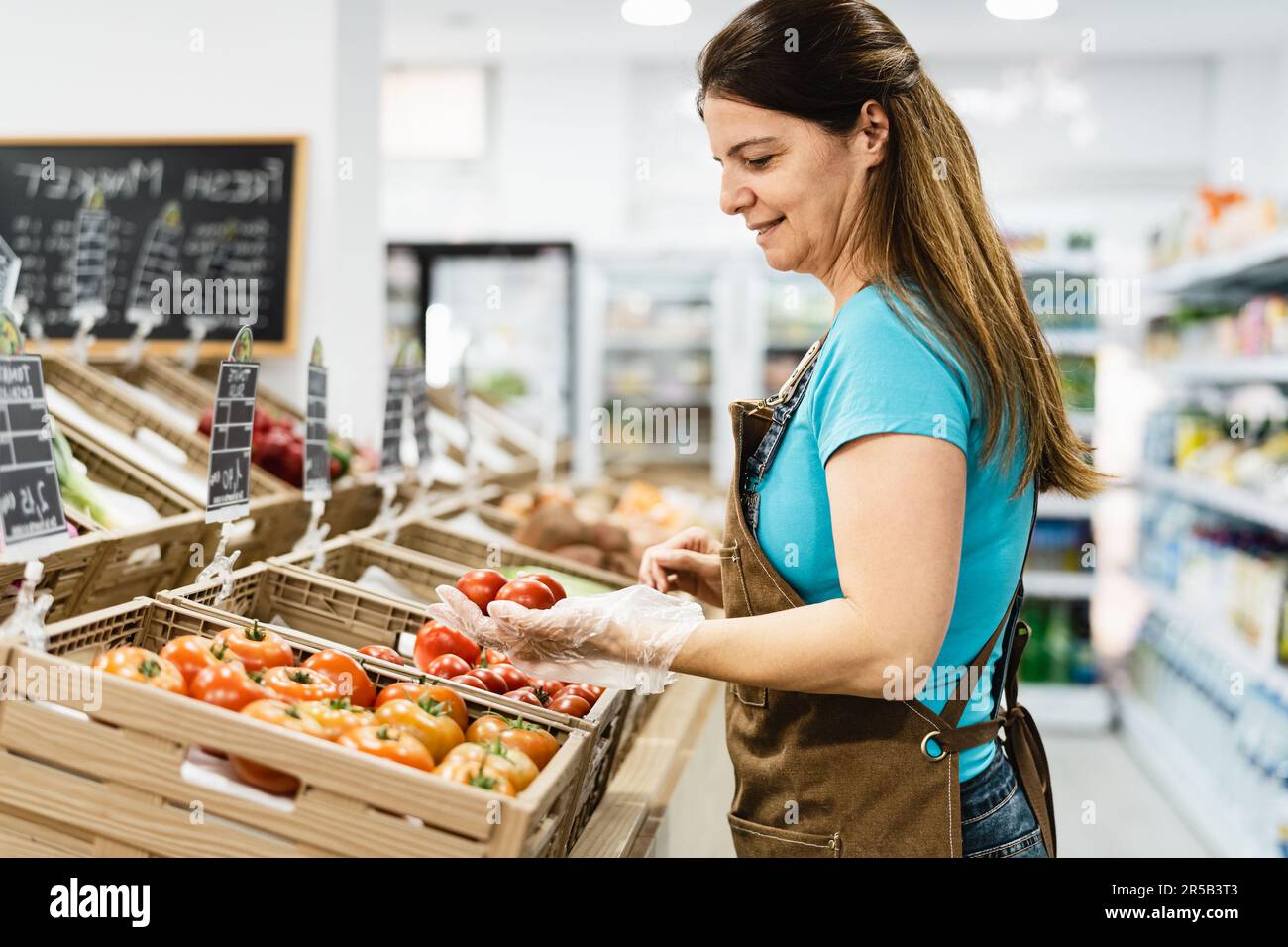 Happy woman working inside grocery store Stock Photo