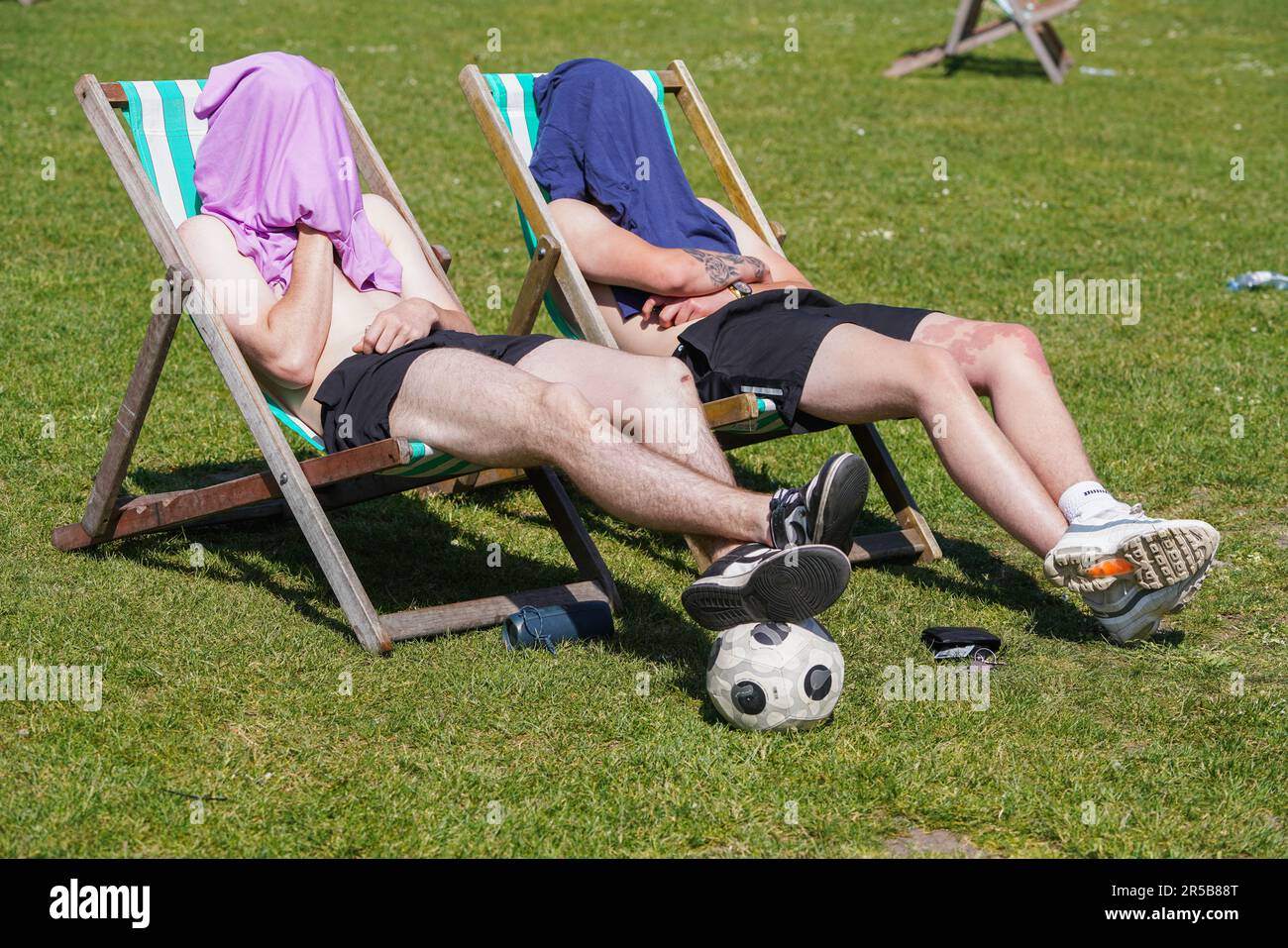 London UK. 2 June 2023 . Two shirtless men sitting in the sunshine with their heads covered  on deckchairs  in Saint James Park . The Met Office forecast warmer temperatures as the country enters the official summer season.Credit: amer ghazzal/Alamy Live News Stock Photo