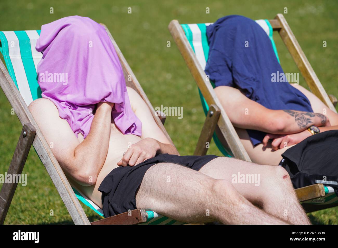 London UK. 2 June 2023 . Two shirtless men sitting in the sunshine with their heads covered  on deckchairs  in Saint James Park . The Met Office forecast warmer temperatures as the country enters the official summer season.Credit: amer ghazzal/Alamy Live News Stock Photo