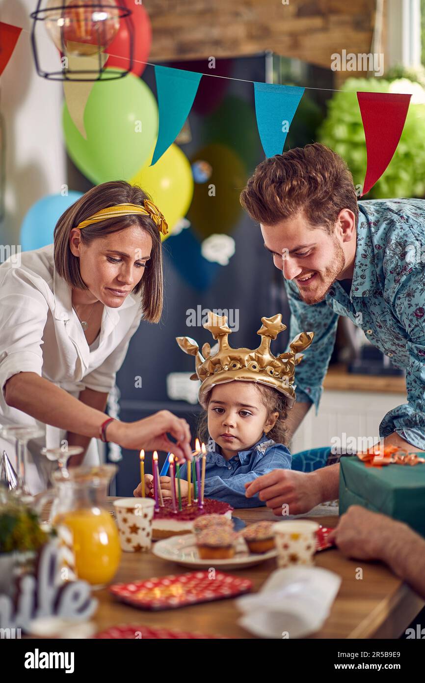 Little girl joyfully celebrates her birthday surrounded by her adoring