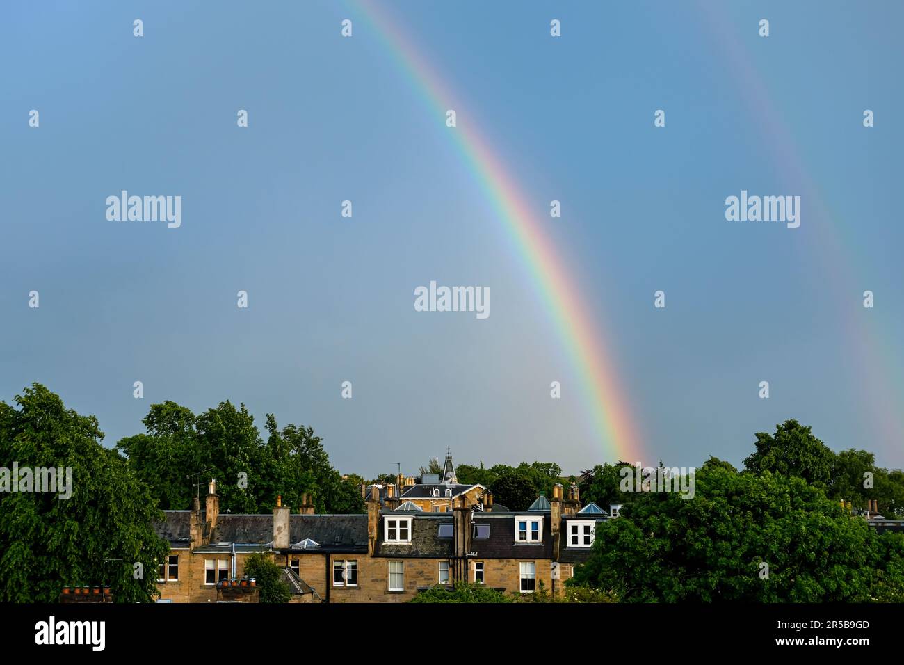 Double Rainbow on Blue Sky after Rain with building in Edinburgh. Stock Photo