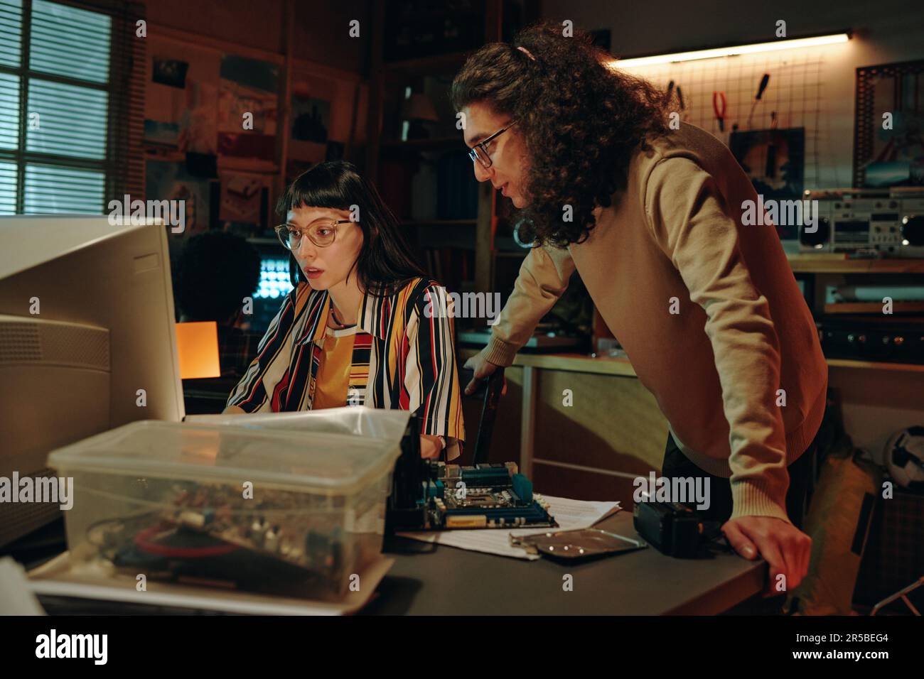 Young people discussing development of software on computer during ...